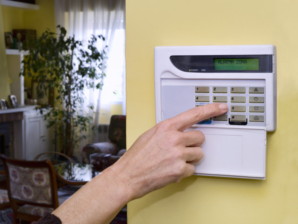 Woman hand turning on home security alarm